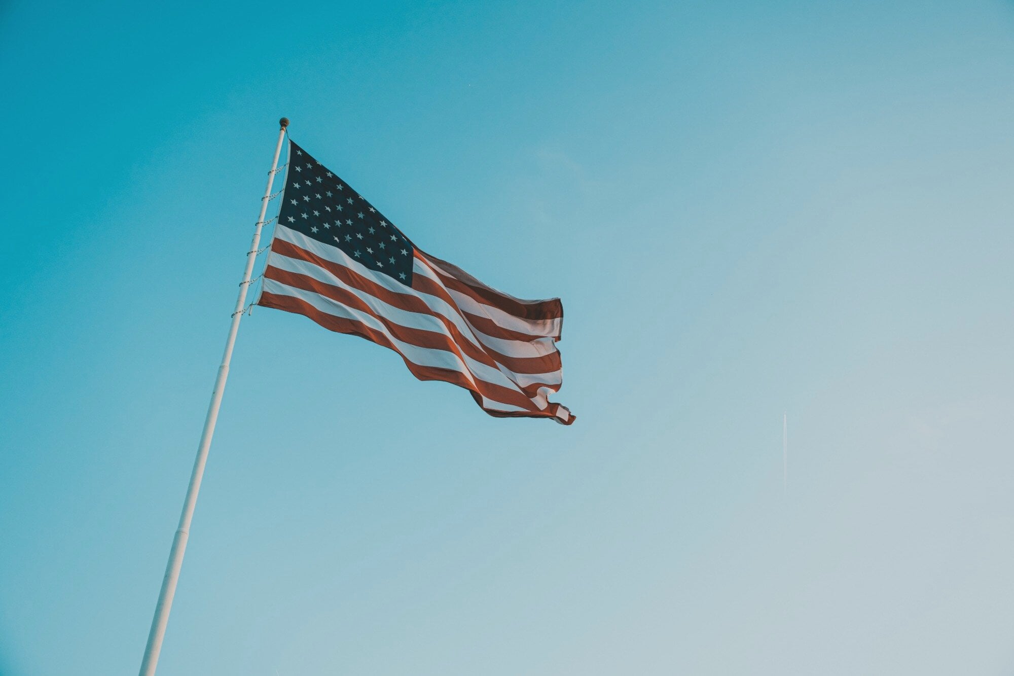 The American flag flying against a clear blue sky